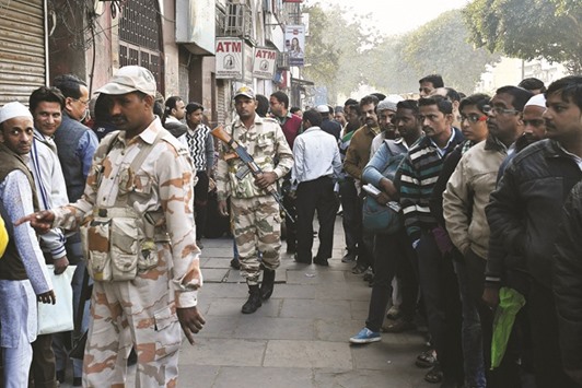 Security personnel patrol the area as people wait in line near a bank branch in New Delhi (file). The hesitation to open Islamic finance channels at  conventional Indian banks could severely limit the attraction for Muslim investors, particularly cash-rich entities, companies and individuals from the Gulf, to put their money into India and thus nip a respective boost for Indiau2019s economy in the bud.