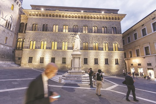 A pedestrian checks his smartphone in front of the Monte dei Paschi headquarters in Siena. The ECBu2019s reported estimate for recapitalisation at Monte dei Paschi is over u20ac3bn, more than judged necessary just one month ago.