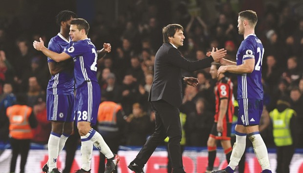 Chelseau2019s Italian head coach Antonio Conte (second right) shakes hands with defender Gary Cahill as other players celebrate after their win over Bournemouth in the English Premier League at Stamford Bridge in London on Monday. (AFP)