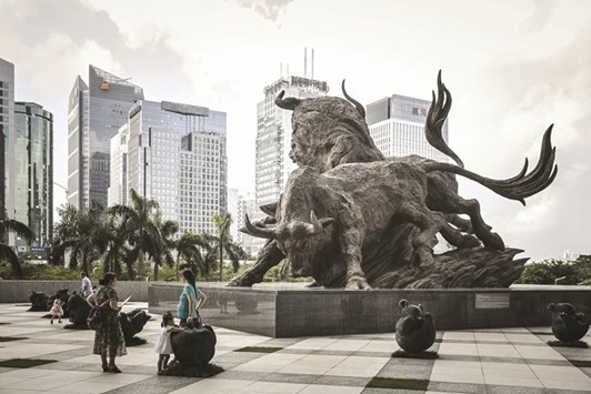 People stand in front of a sculpture of bulls at the entrance to the Shenzhen Stock Exchange building. Chinau2019s markets are seeing renewed pressure this month as the Federal Reserve projects a faster pace of rate increases for 2017 and its Chinese counterpart tightens monetary conditions to spur deleveraging and defend the exchange rate.