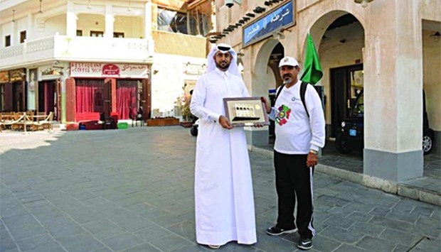 Saudi adventurer Nasser Mohamed Al Jarallah al-Qahtani receiving a memento from a Qatari official at Souq Waqif in Doha.