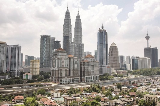 A view of the Petronas Twin Towers in Kuala Lumpur. Petronasu2019s Pacific NorthWest LNG project would continue as planned with the liquefaction plant on Lelu Island in British Columbia. The company would move the docking facilities to neighbouring Ridley Island, where ships would berth to take deliveries of the fuel for export, according to two people familiar with the negotiations.