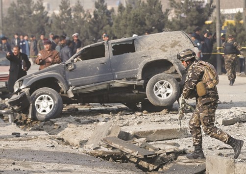Afghan security forces inspect the site of a blast in Kabul, Afghanistan yesterday.