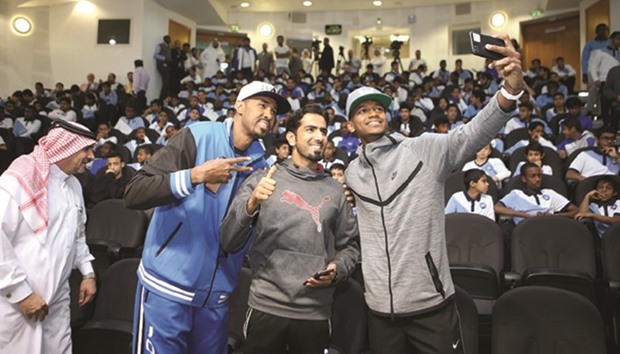 Mutaz Barshim, Mohamed Saadon al-Kuwari and Yasseen Ismail take selfies with student-athletes.
