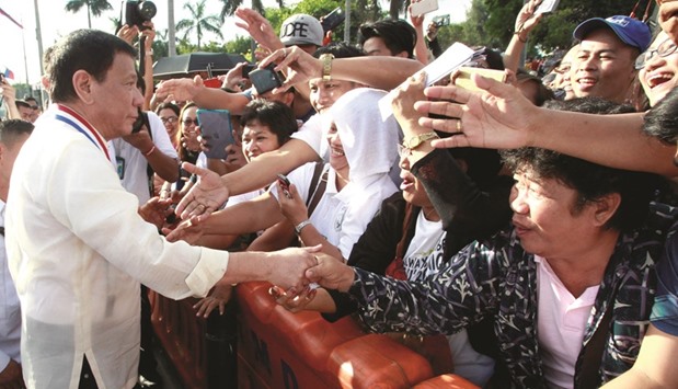 Duterte shakes hands with supporters as he leads the death anniversary celebration of Filipino national hero Dr Jose Rizal in Manila.