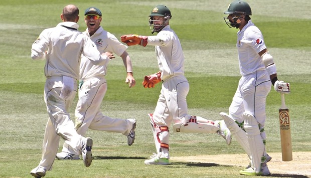 Pakistanu2019s Misbah-ul-Haq (right) walks off after been dismissed by Australiau2019s Nathan Lyon (left) on the final day of the second Test in Melbourne yesterday. (AFP)