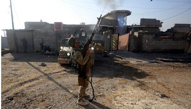 A member of the Iraqi forces fires a gun in Mosul's eastern Al-Intisar neighbourhood during an ongoing military operation against Islamic State group jihadists.