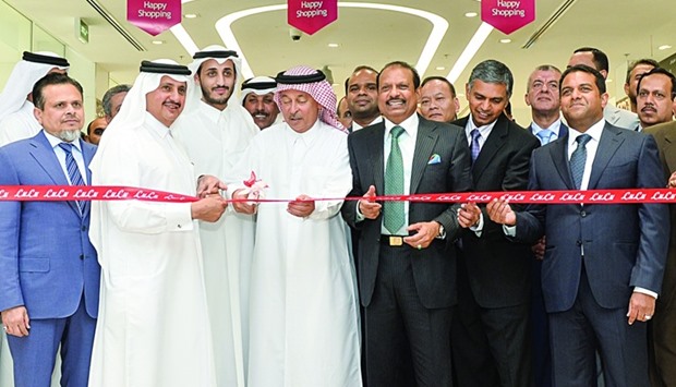 Sheikh Khalifa bin Jassem bin Mohamed al-Thani cuts a ribbon to mark the opening of LuLu Hypermarket as Yusuffali MA, Sheikh Khaled bin Hassan al-Thani and others look on.