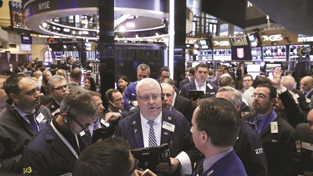 Traders work on the floor of the New York Stock Exchange. The S&P 500 will climb 5.2% in 2017, according to estimates from analysts who had made a projection by December 19.