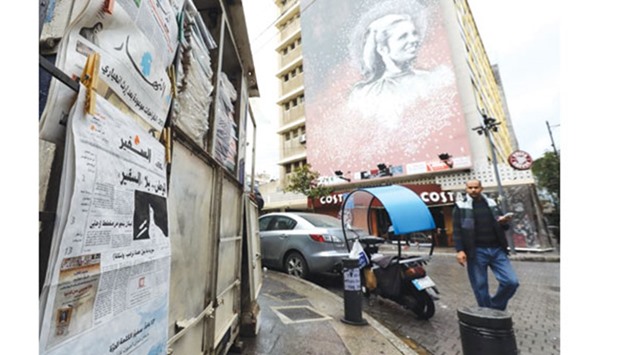 A man walks past a newspaper stand, displaying the As-Safir newspaper, in Beirutu2019s Hamra neighbourhood yesterday.