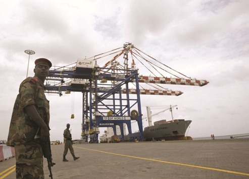 A Djibouti policeman stands guard during the opening ceremony of DP Worldu2019s Doraleh container terminal in Djibouti port (file). DP World, which operates ports from China to South America, will own 55% of the unnamed venture, with the Montreal-based Caisse controlling the remainder, according to a statement on Friday.