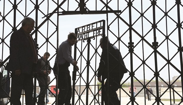 This file photo taken on April 29, 2015 shows workers fixing the new entrance gate door of the former concentration camp in Dachau, southern Germany. The old entrance gate had been stolen on November 2, 2014.
