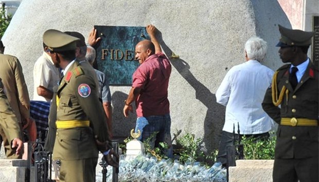 Workers fix the plaque with his name on Cuban leader Fidel Castro's tomb at the Santa Ifigenia Cemetery in Santiago on Sunday.