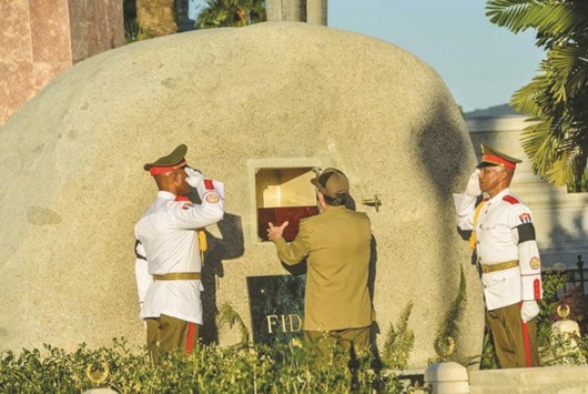 Cubau2019s President Raul Castro (centre) places the box containing the ashes of former president Fidel Castro into a boulder at the Santa Ifigenia Cemetery, in Santiago de Cuba, yesterday.