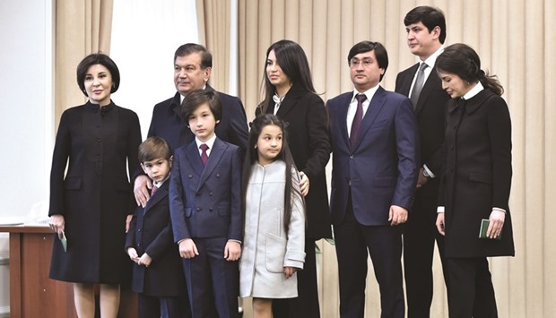 Mirziyoyev poses for photographers with his family after voting at a polling station in Tashkent.