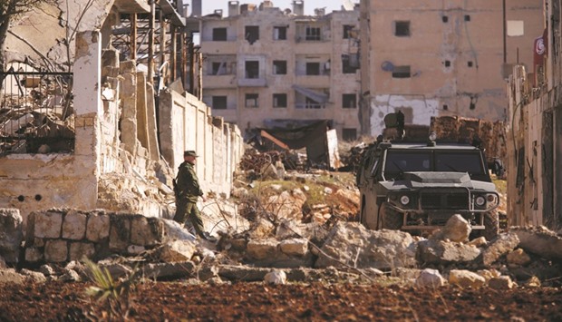 A Russian soldier walks to a military vehicle in government-controlled Hanono housing district in Aleppo yesterday.