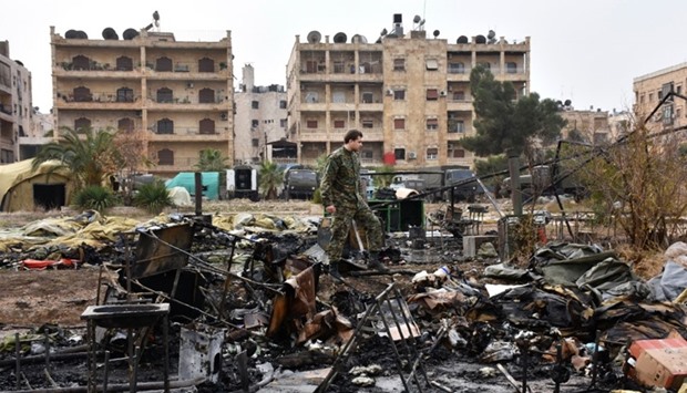 A Russian soldier inspects the damage at a field hospital that was reportedly destroyed by rebel shelling on December 5, 2016 in the Furqan neighbourhood of the government-held side of west Aleppo.  AFP