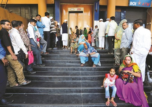 People wait for a bank to open to withdraw and deposit their money in Ahmedabad yesterday.