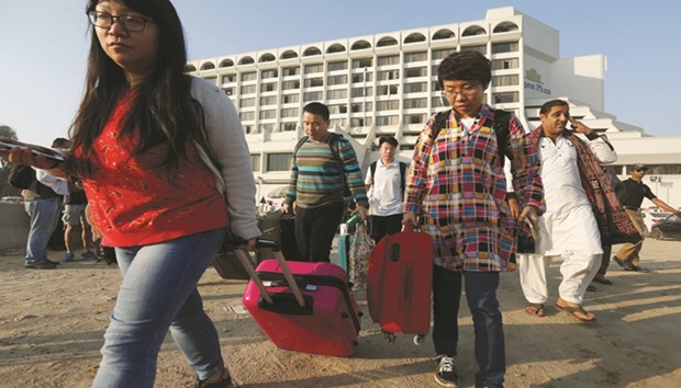 Foreign guests leave after a fire erupted in a hotel early morning in Karachi yesterday.