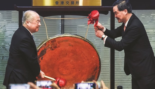 HKEX chairman CK Chow (left) and Hong Kongu2019s chief executive Leung Chun-ying strike a gong to mark the start of the Shenzhen-Hong Kong Stock Connect yesterday.  A long-delayed trading link between the Chinese city of Shenzhen and Hong Kong launched, opening another door to the mainlandu2019s cosseted stock markets but a China slowdown, weak yuan and expected US rate hikes have analysts sounding a note of caution.