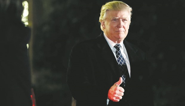 US President-elect Donald Trump gives a thumbs up to the media as he arrives at a costume party at the home of hedge fund billionaire and campaign donor Robert Mercer in Head of the Harbor, New York. Trump took on Chinau2019s government  in a series of tweets criticising it for currency manipulation, barriers to foreign competition and militarising the South China Sea.