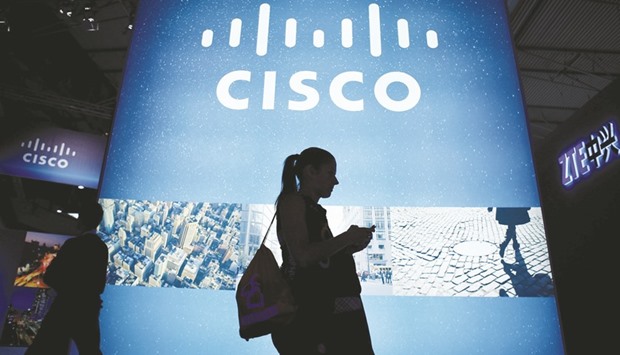 A visitor walks past a Cisco advertising panel as she looks at her mobile phone at the Mobile World Congress in Barcelona. Over the next two weeks officers and alumni of Cisco Systems will be taking the stand in a copyright trial in San Jose, California. The case is part of a broader legal fight pitting the worldu2019s largest networking equipment maker against upstart rival Arista Networks.