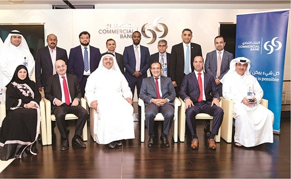 Commercial Bank and Qatar Cool officials mark the partnership.