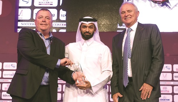 Secretary General of the Supreme Committee for Delivery and Legacy Hassan al-Thawadi (C) and Tony Martin present Duncan Revie Award to chairman of Sheffield FC Richard Tims