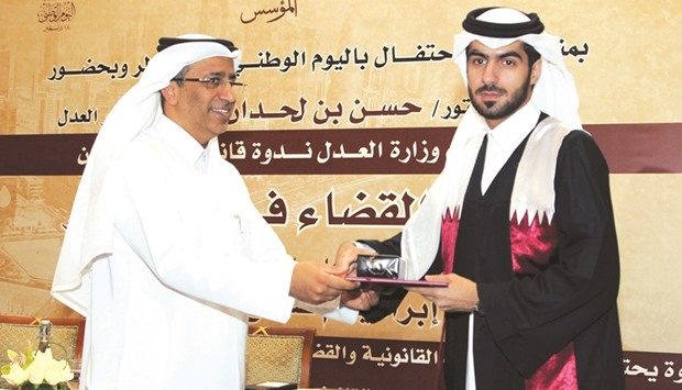 HE the Justice Minister Dr Hassan Lahdan Saqr al-Mohannadi presenting a certificate.