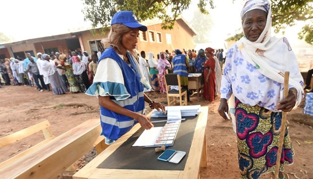 A woman prepares to vote for the presidential election at a polling station in Bole district, Ghana