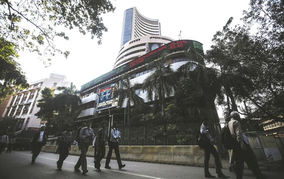 People walk by the Bombay Stock Exchange building in Mumbai. The 30-share BSE Sensex closed down 155.89 points to 26,236.87 yesterday.
