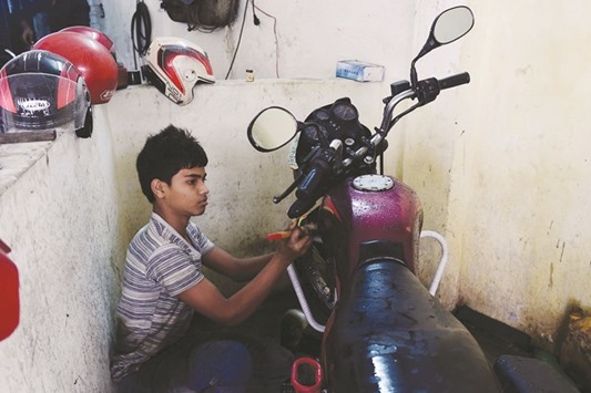 Bangladeshi worker Russel, and who says he will turn 14 next year, works in a garage in Dhaka yesterday.