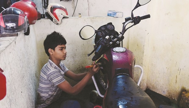 Bangladeshi worker Russel, and who says he will turn 14 next year, works in a garage in Dhaka yesterday.
