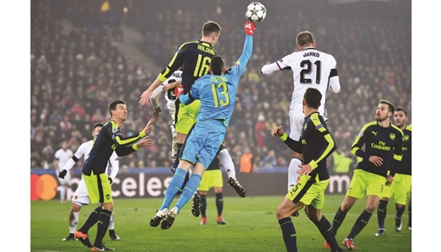 Arsenal goalkeeper David Ospina (C) jumps to make a save during the Champions league match against FC Basel.