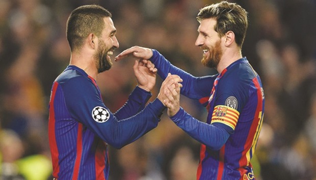 Barcelonau2019s Turkish forward Arda Turan (L) celebrates with teammate Lionel Messi after scoring a goal.