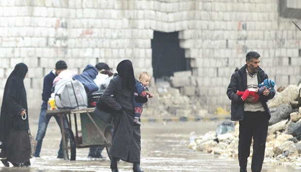 Civilians carry their belongings as they flee deeper into the remaining rebel-held areas of Aleppo yesterday.