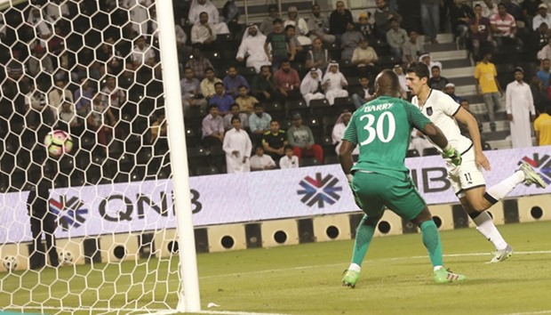 Al Saddu2019s Bagdad Bounedjah (right) scores past Al Rayyan goalkeeper Omar Barry during the Qatar Stars League match yesterday. PICTURES: Jayan Orma
