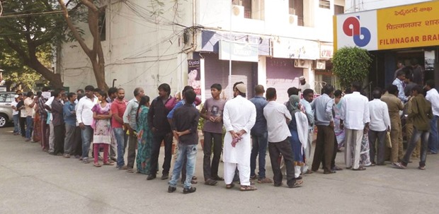 People queue up outside an ATM in Hyderabad yesterday. Across the country millions continued to experience hardships a month after the government announced demonetisation of high value currency notes.