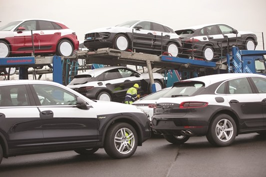 Porsche Macan sport utility vehicles sit on an automobile transporter ahead of shipping from the Porsche factory in Leipzig. German authorities are examining whether Porsche installed devices allowing its cars to sense whether they were being tested for fuel consumption and carbon-dioxide emissions, officials said yesterday.