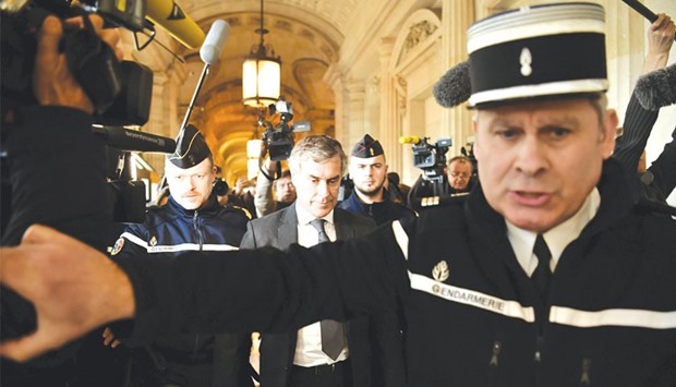 Gendarmes escort Cahuzac as he leaves the Paris courthouse following his tax fraud and money laundering trialu2019s verdict.