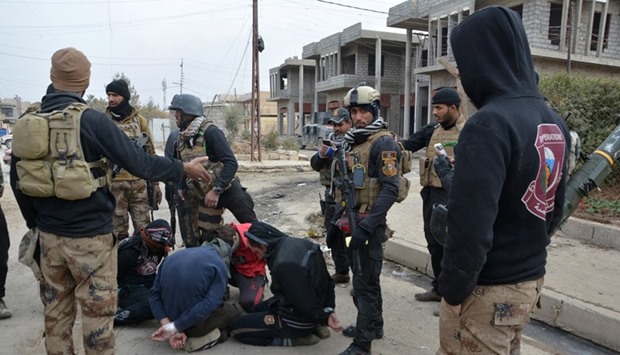 Handcuffed men, who according to the Iraqi security forces are suspected Islamic State militants, are seen in Eelam neighborhood east of Mosul.