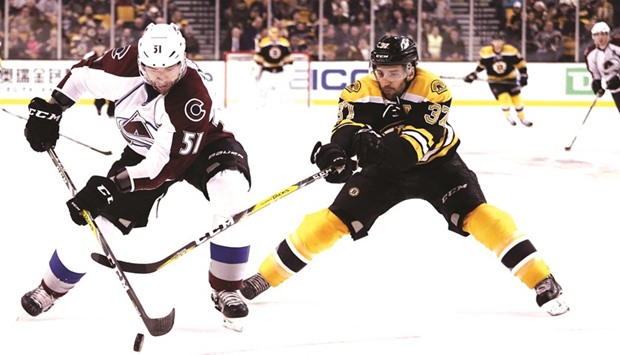 Patrice Bergeron (right) of Boston Bruins battles for the puck with Fedor Tyutin of the Colorado Avalanche during the first period of their NHL game in Boston. (AFP)