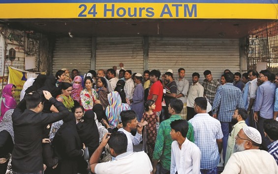 People queue outside a bank to withdraw cash and deposit their old high denomination bank notes in Mumbai.