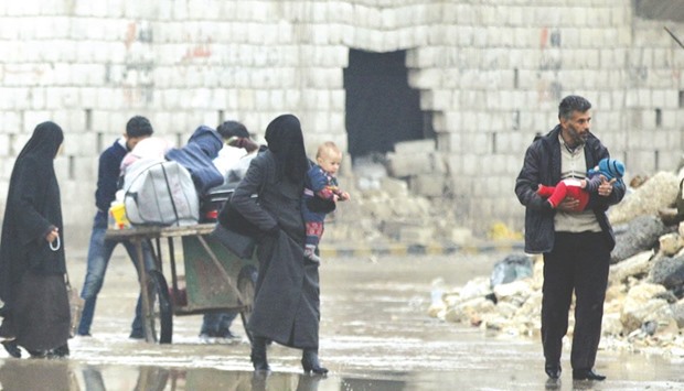 Civilians carry their belongings as they flee deeper into the remaining rebel-held areas of Aleppo, Syria.