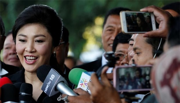 Yingluck Shinawatra speaks with members of Thai media as she arrives at the Supreme Court for a trial on criminal negligence in Bangkok on Friday.