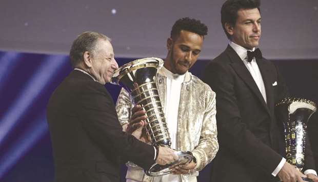 FIA president Jean Todt (left) presents the Formula 1 driveru2019s championship trophy to Lewis Hamilton (centre) while Mercedes F1 team boss Toto Wolff looks on during the FIA Prize Giving in Versailles, France, on Friday. (FIA)