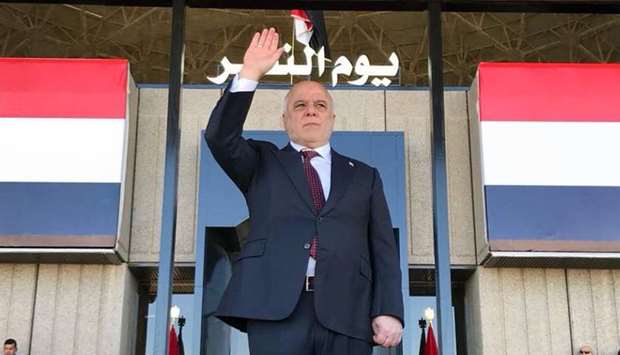 Prime Minister Haider al-Abadi greeting Iraqis in the capital Baghdad at the start of a military parade to mark the end of a three-year war against the Islamic State group.