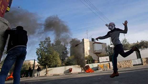 A Palestinian protester throws stones towards Israeli forces during clashes in the West Bank town of Bethlehem on Sunday.
