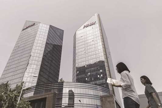 Pedestrians walk past the HNA Group building in Beijing. HNAu2019s New York-based charity has begun an assessment that may shed light on the mysterious top shareholder of the Chinese conglomerate that owns large stakes in Deutsche Bank and Hilton Worldwide Holdings.