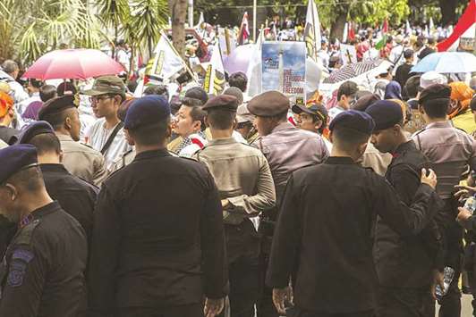 Indonesian police stand guard as demonstrators attend a protest against US President Donald Trumpu2019s recognition of Jerusalem as the capital of Israel, outside the US embassy in Jakarta yesterday.